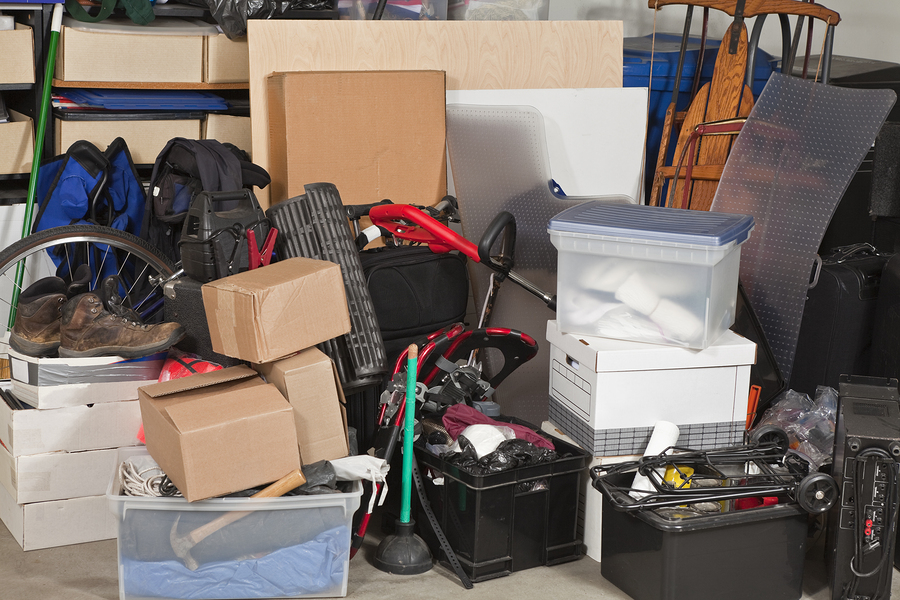 A pile of boxes and other items in a cluttered room.