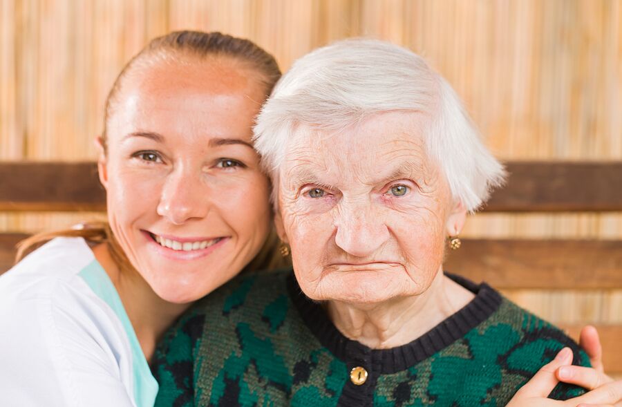 A woman and an old lady smiling for the camera.