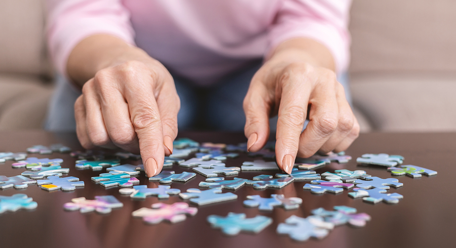 A person is playing with a puzzle on the table.