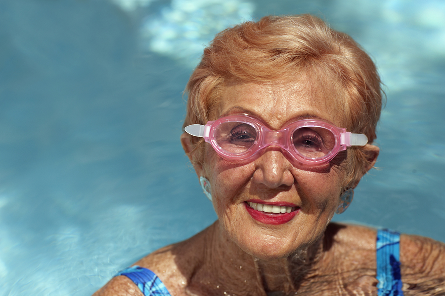 A woman in pink glasses is swimming.