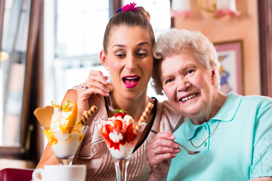 A woman and an older lady eating ice cream.