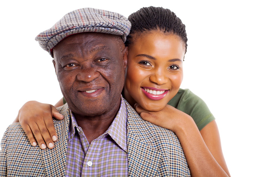 A woman hugging an older man in front of white background.