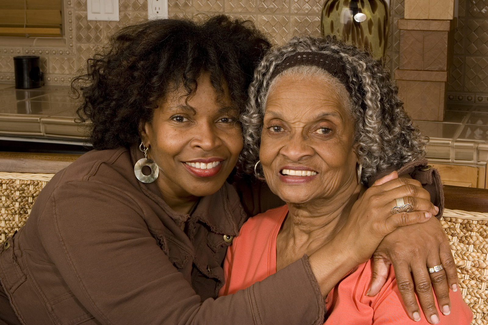 Two women are hugging and smiling for the camera.