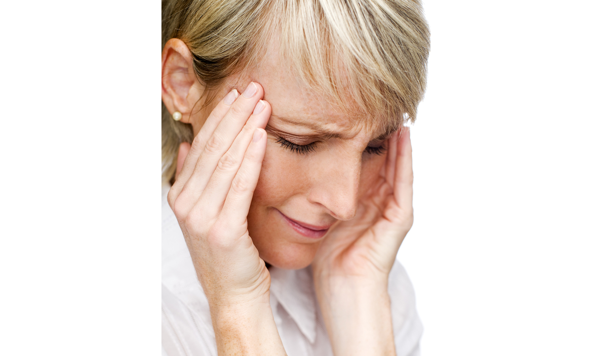 A woman holding her head in pain with both hands.