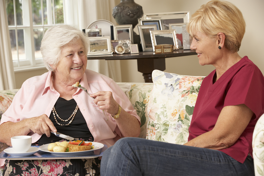 A woman and an older lady eating food.
