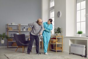 A man and woman in blue scrubs playing with a stick.