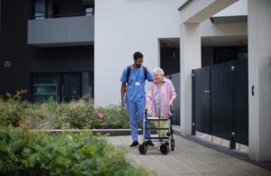 A nurse and an elderly woman walking down the street