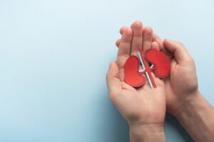 A person holding two hands with paper cut out hearts.